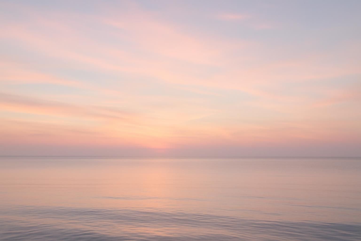 A soft pastel sky over a calm gulf horizon near Houston, TX